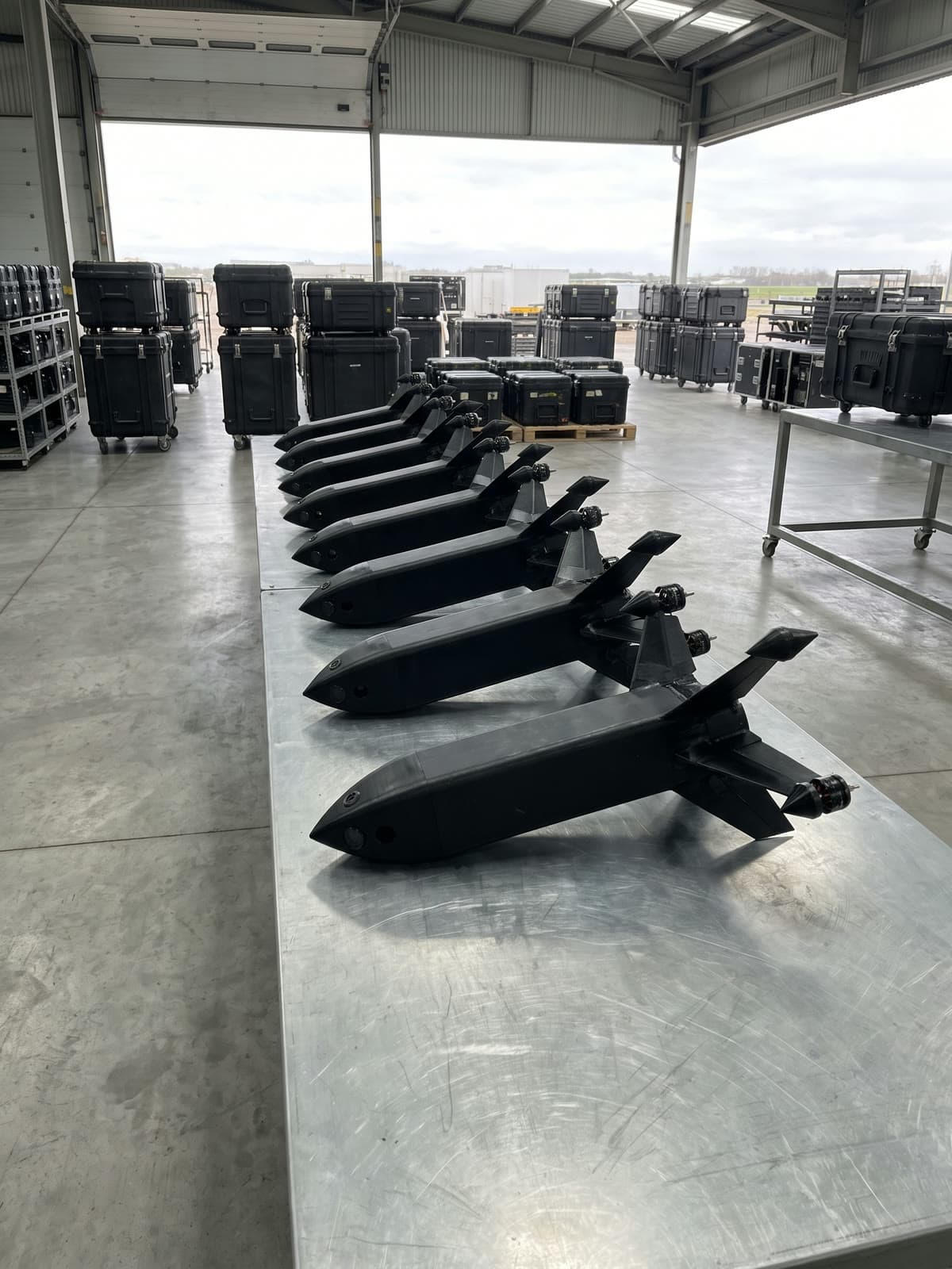Rząd czarnych dronów przechwytujących na ocynkowanym blacie w hangarze